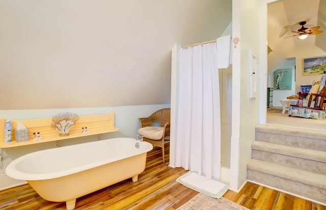 bathroom with hardwood / wood-style floors, a washtub, ceiling fan, and lofted ceiling