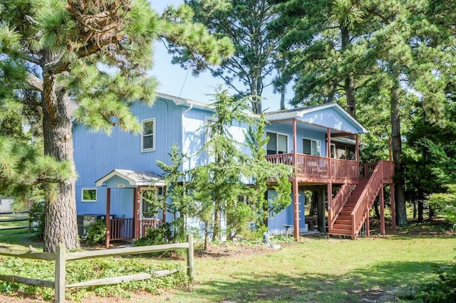 rear view of property with covered porch and a yard