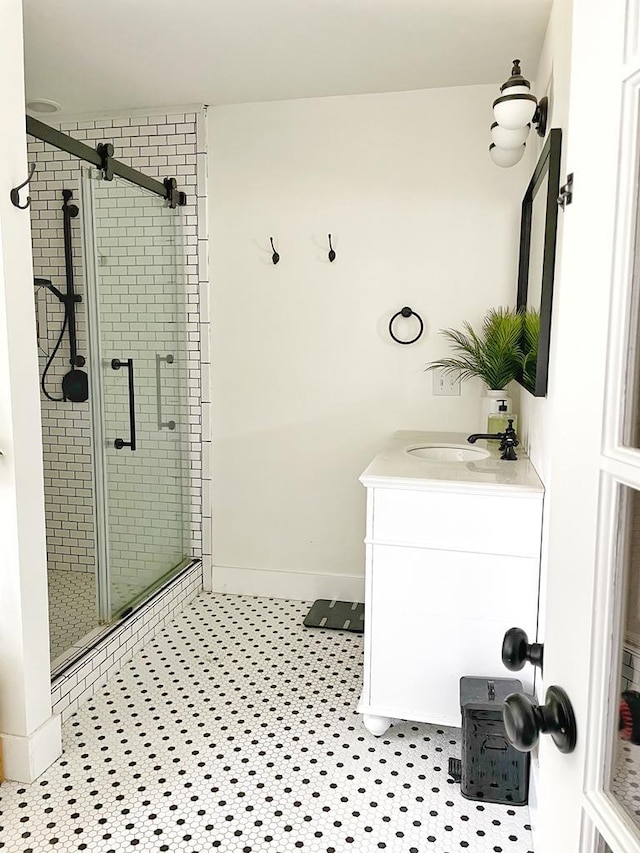 bathroom with tile patterned floors, a shower with door, and vanity