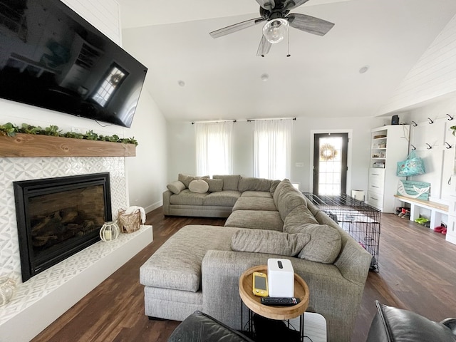 living room with a tile fireplace, ceiling fan, dark hardwood / wood-style flooring, and high vaulted ceiling