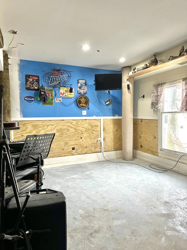 rec room with unfinished concrete flooring