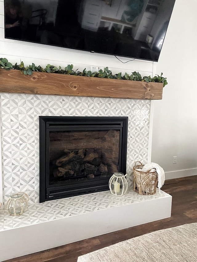 room details with wood finished floors, a fireplace, and baseboards