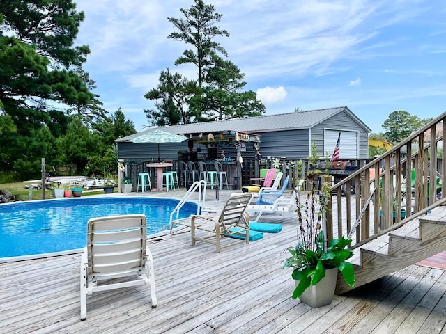 outdoor pool with outdoor dry bar and a deck