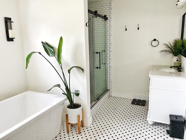 full bathroom with a freestanding tub, baseboards, vanity, and a shower stall