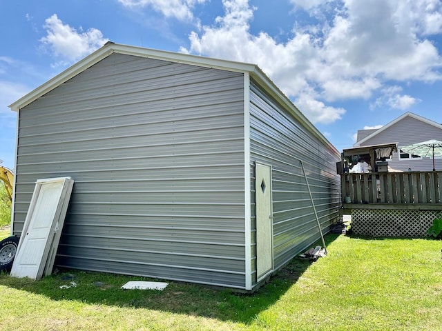 view of side of home with a deck and a lawn