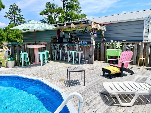 exterior space featuring a pool side deck and exterior bar