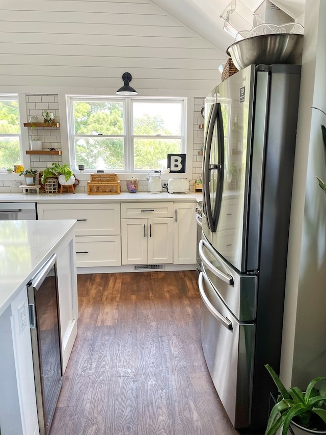 kitchen with beverage cooler, dark wood-style flooring, light countertops, white cabinets, and appliances with stainless steel finishes