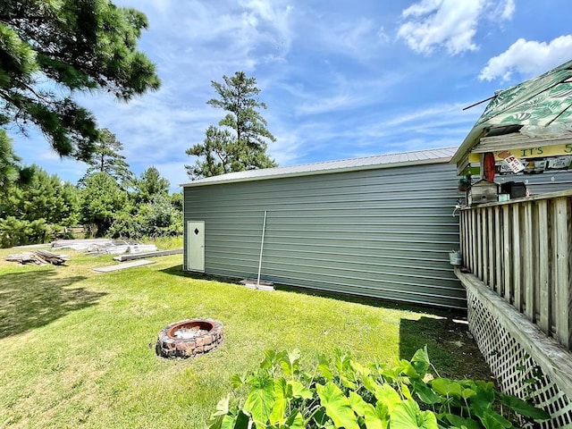 view of side of home with a yard and an outdoor fire pit