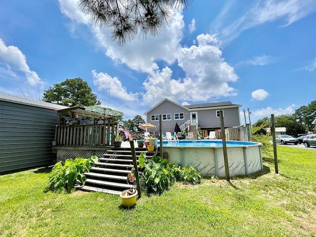 rear view of house featuring stairway, a yard, an outdoor pool, and a wooden deck