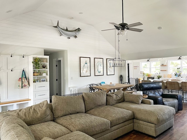 living room featuring ceiling fan with notable chandelier, dark hardwood / wood-style floors, and high vaulted ceiling