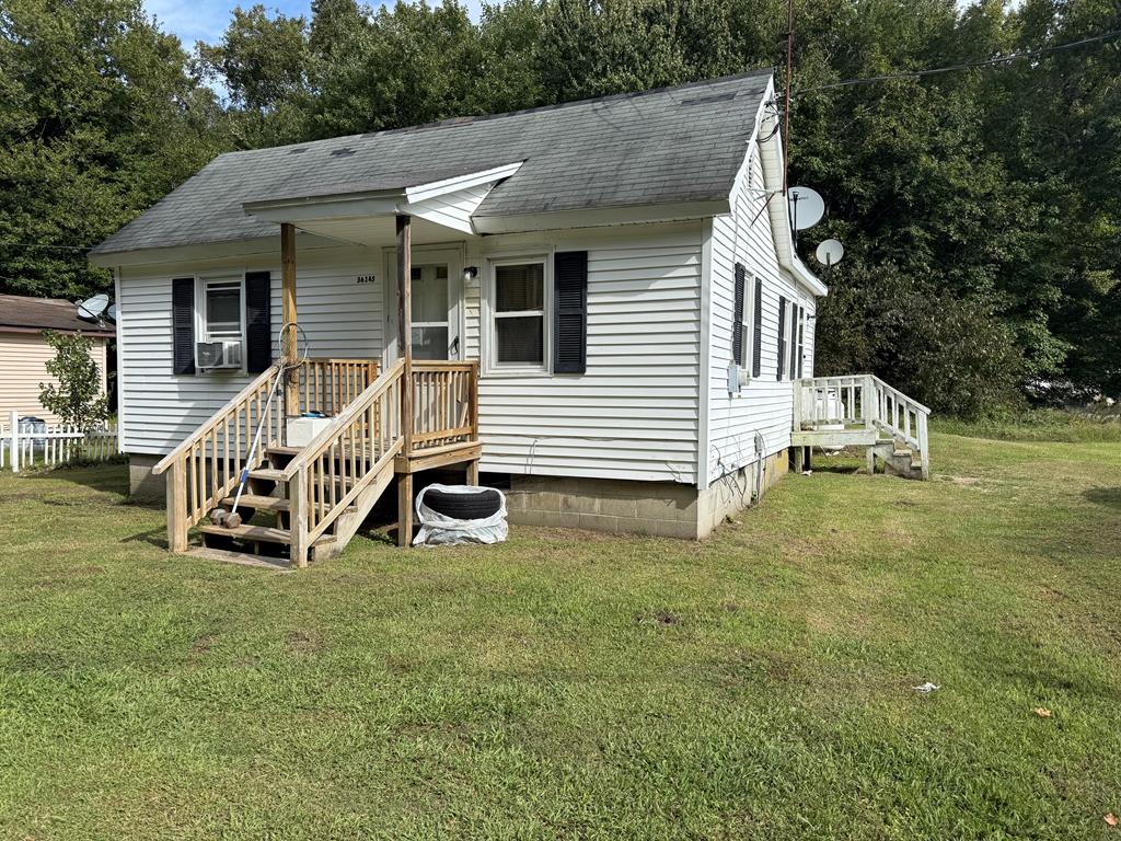 view of front of house with a front yard and cooling unit