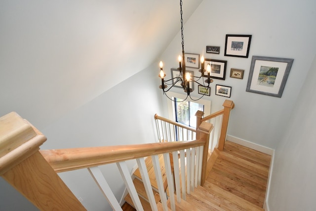 420 Randolph Ave, Cape Charles, VA 23310 - stairway with wood finished floors, a chandelier, lofted ceiling, and baseboards