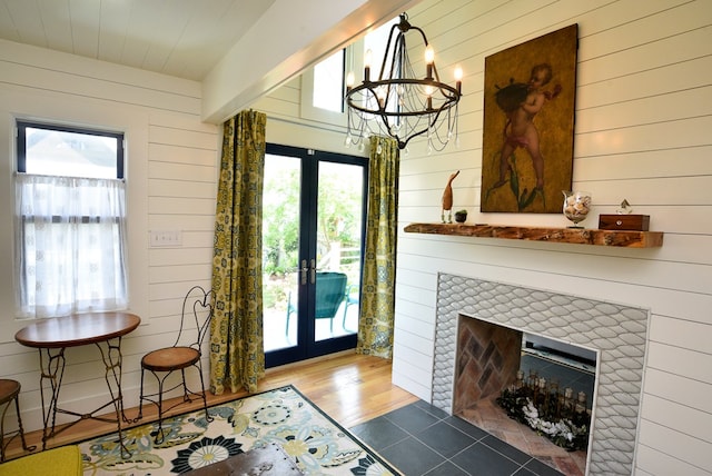 420 Randolph Ave, Cape Charles, VA 23310 - entryway featuring french doors, wooden walls, wood finished floors, a chandelier, and a fireplace