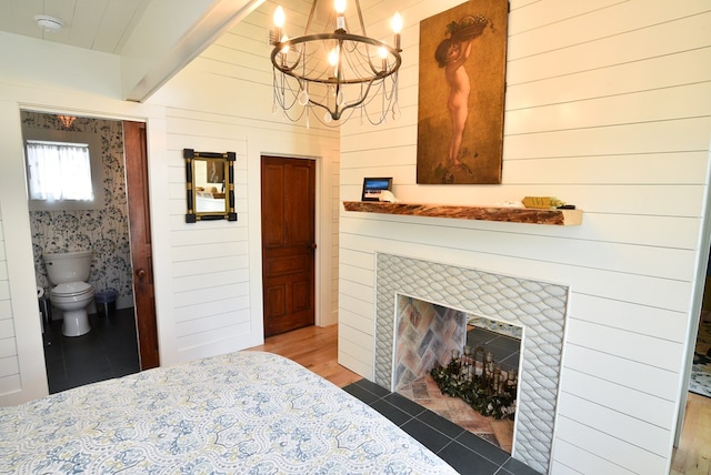 420 Randolph Ave, Cape Charles, VA 23310 - bedroom featuring a chandelier, a tile fireplace, tile patterned floors, and beam ceiling