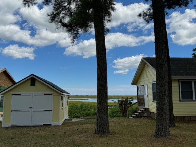 view of yard with a storage unit and a water view