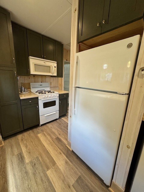 kitchen with white appliances and light hardwood / wood-style flooring