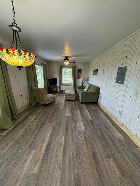 unfurnished living room featuring electric panel, ceiling fan, and dark wood-type flooring