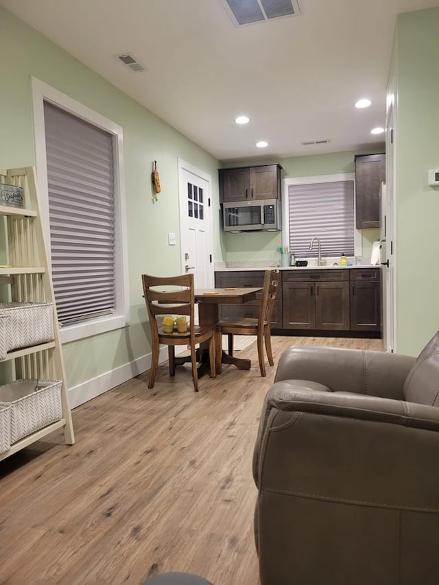 living room with light hardwood / wood-style floors and sink