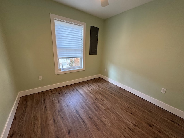 spare room with electric panel, ceiling fan, and hardwood / wood-style flooring