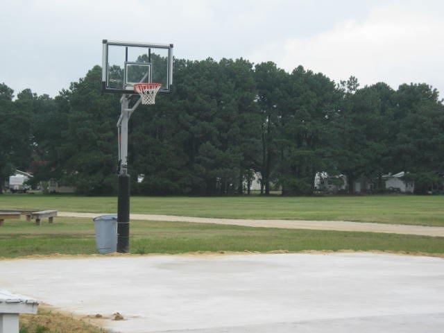 view of sport court featuring a lawn