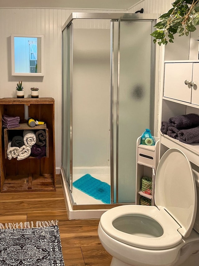 bathroom featuring wood-type flooring, toilet, and walk in shower