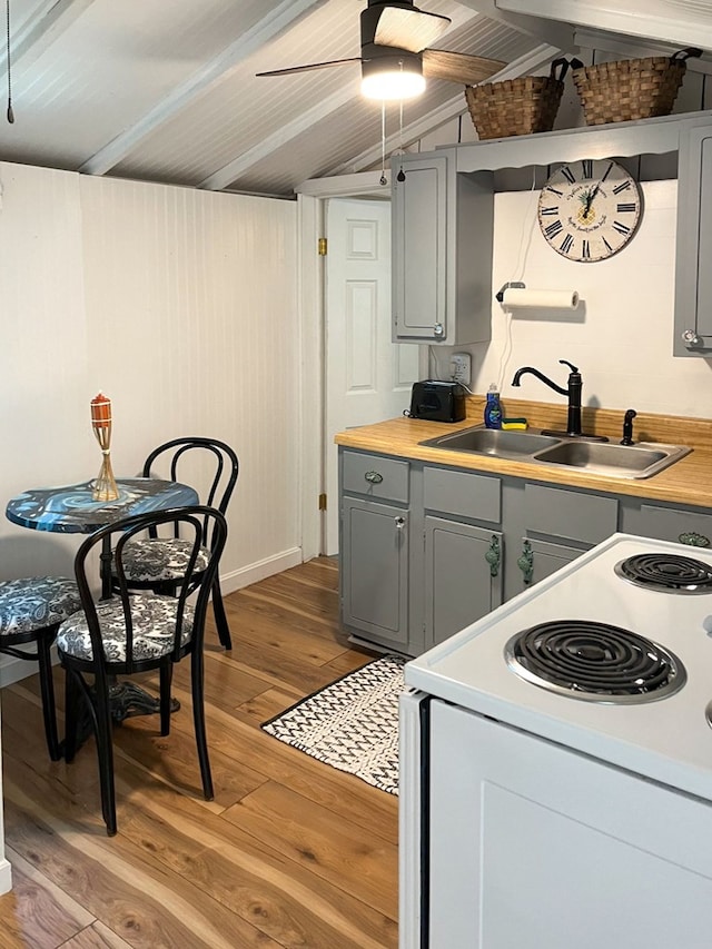 kitchen with gray cabinetry, white electric range, sink, vaulted ceiling with beams, and light wood-type flooring