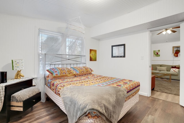 bedroom with dark hardwood / wood-style flooring and ceiling fan