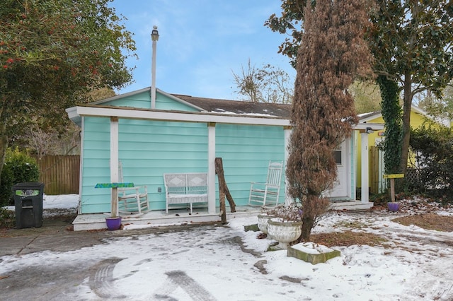 view of snow covered rear of property