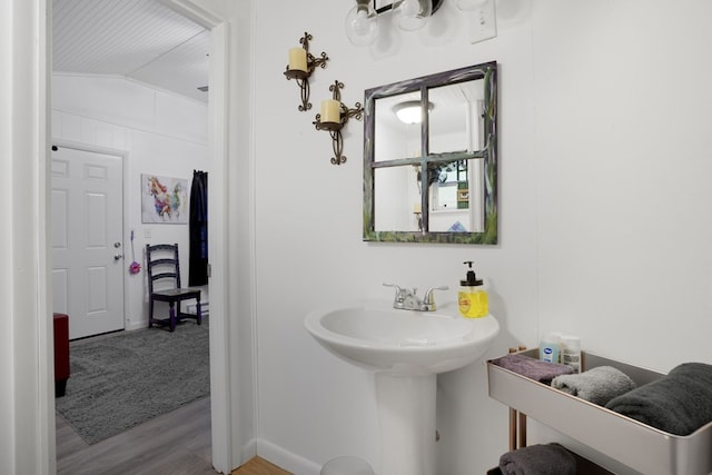 bathroom with hardwood / wood-style floors and lofted ceiling