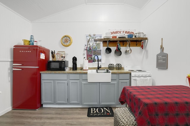 kitchen featuring gray cabinets, electric range, refrigerator, and lofted ceiling