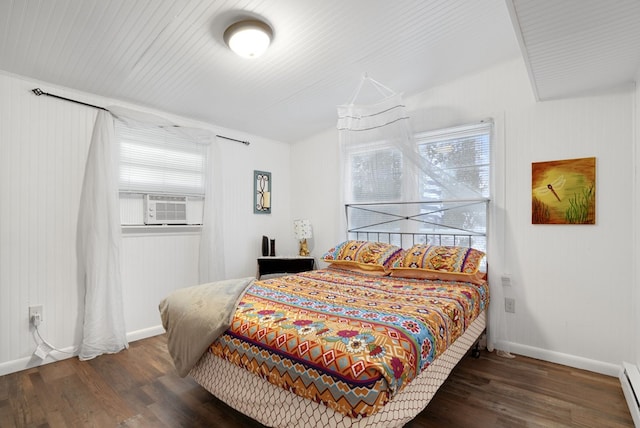 bedroom with dark hardwood / wood-style flooring and baseboard heating