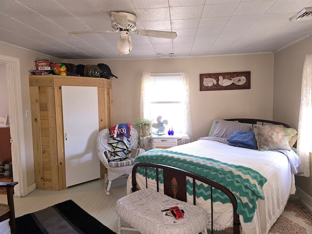 bedroom with crown molding, ceiling fan, and light hardwood / wood-style flooring