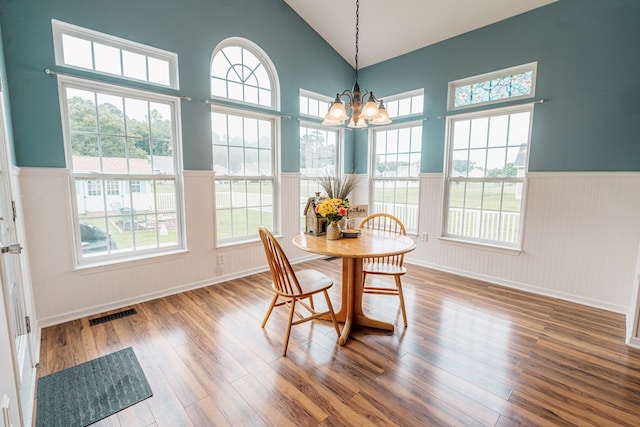 37275 Longboat Ct, Greenbackville, VA 23356 - dining space with wainscoting, wood finished floors, a chandelier, and high vaulted ceiling