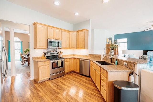 37275 Longboat Ct, Greenbackville, VA 23356 - kitchen featuring appliances with stainless steel finishes, light brown cabinetry, ornate columns, light wood-style floors, and open floor plan