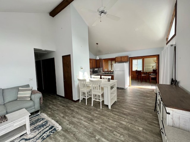 living area with high vaulted ceiling, a ceiling fan, dark wood finished floors, and beam ceiling