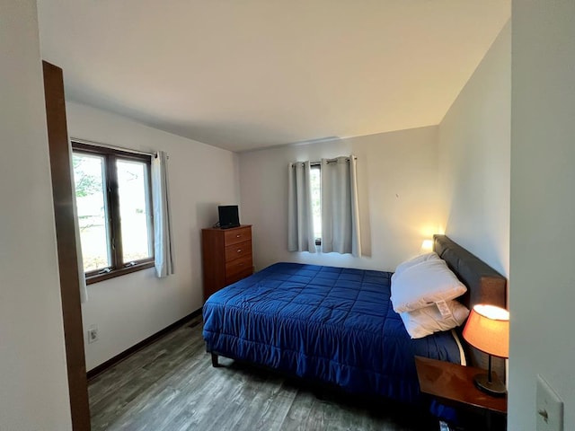 bedroom featuring dark wood-style floors and baseboards