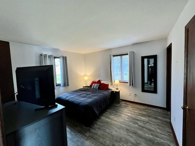 bedroom with dark wood-style floors and baseboards