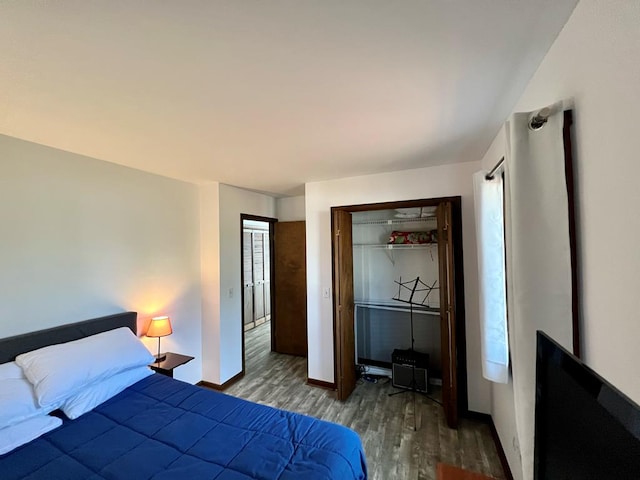 bedroom featuring a closet, wood finished floors, and baseboards