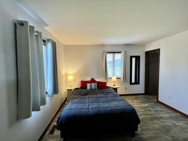 bedroom with visible vents, baseboards, and dark wood finished floors