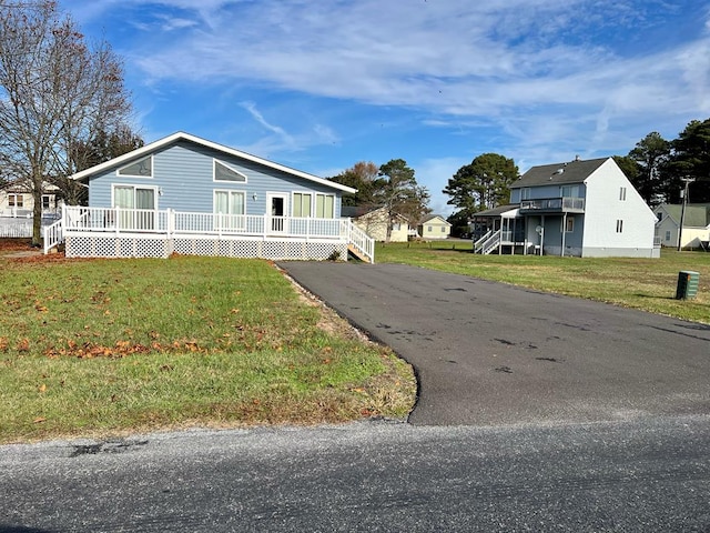 view of side of home featuring a deck, a yard, and driveway