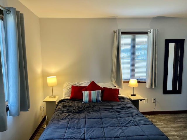 bedroom featuring dark wood-style floors and baseboards