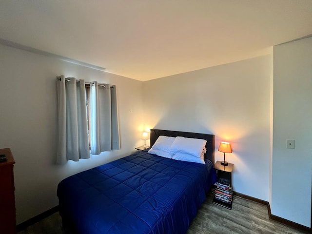 bedroom featuring baseboards and wood finished floors