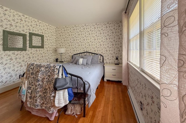 35197 Hillsborough Dr, Belle Haven, VA 23306 - bedroom featuring wallpapered walls, wood finished floors, a baseboard heating unit, and baseboards