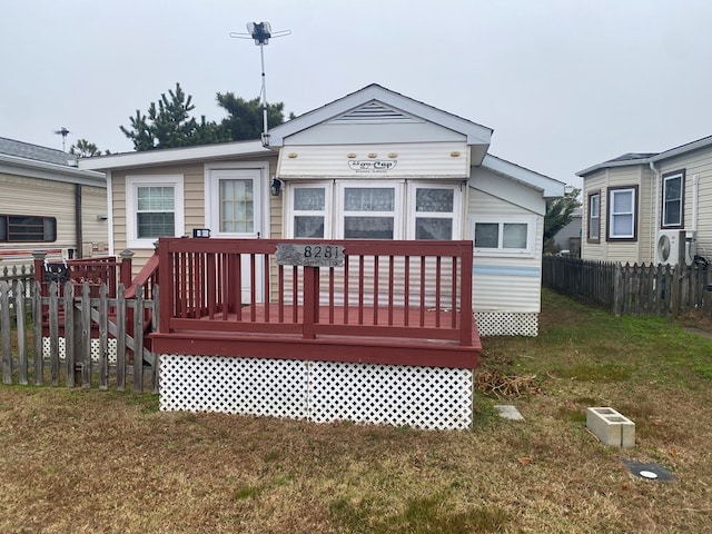 back of house with a wooden deck and a yard