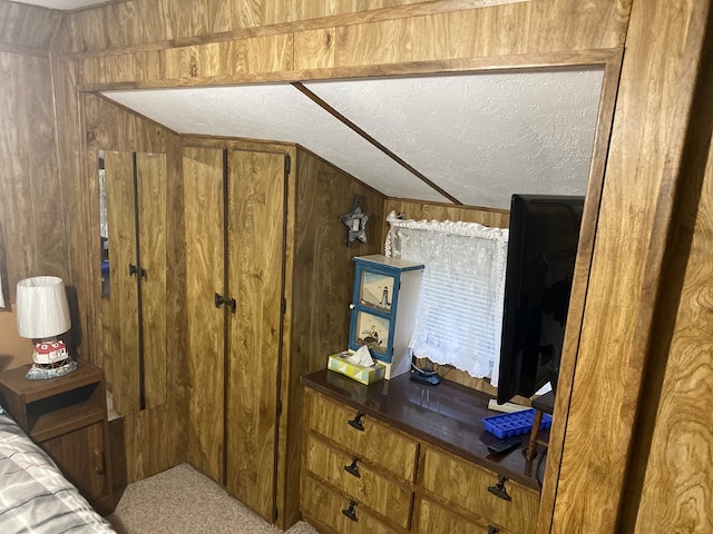 bedroom with wooden walls and a textured ceiling