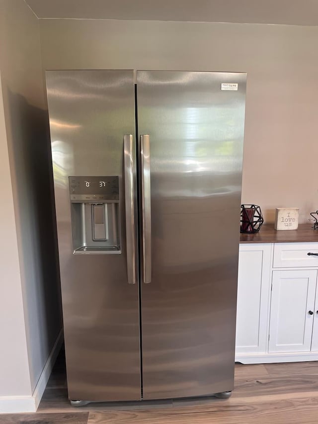 3469 Willis Wharf Rd, Exmore, VA 23350 - detailed view of stainless steel refrigerator with ice dispenser and wood finished floors
