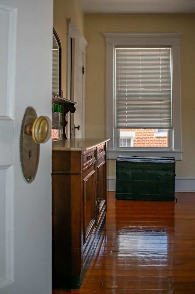 bar featuring dark wood-type flooring and baseboards