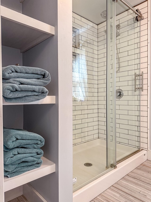 full bathroom featuring a stall shower and wood finished floors