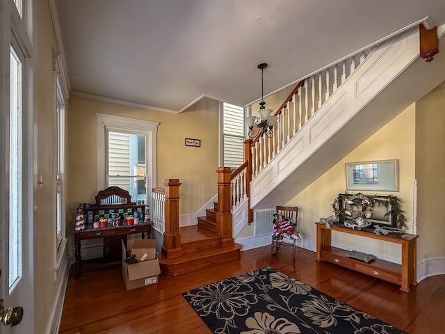 interior space featuring hardwood / wood-style flooring, baseboards, stairway, and crown molding