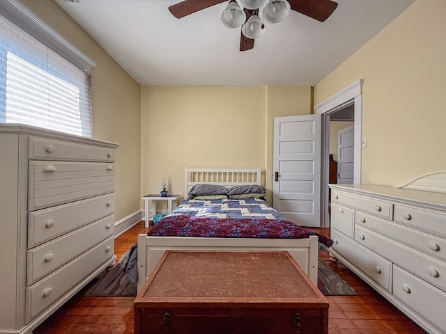 bedroom with a ceiling fan, dark wood-style flooring, and baseboards